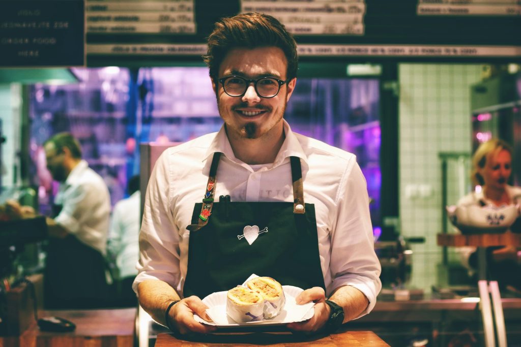 Restaurant owner serving food in a busy Belfast restaurant